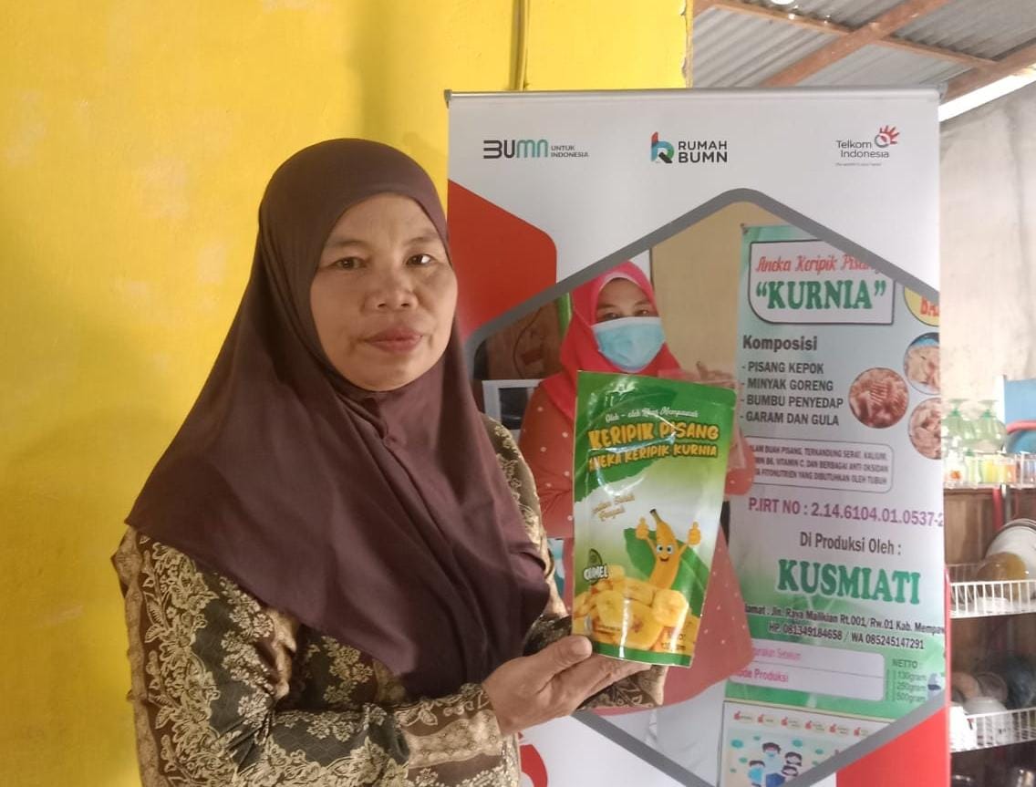 Kusmiati, pemiliki usaha Aneka Keripik Pisang “Kurnia” yang merupakan salah satu UMKM di Rumah BUMN Mempawah Kalimantan Barat yang telah melakukan upgrade packaging di bawah binaan Telkom ( Foto : Istimewa ).